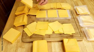 Separating clusters of cheese singles and sorting into smaller piles to be wrapped in wax paper and freeze or stored in fridge.