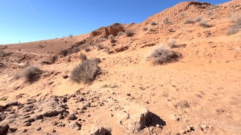 clip-3986293617-woman-walking-away-on-desert-trail-sunny