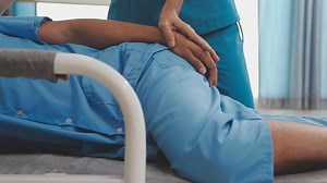 Download Doctor or Physiotherapist working examining treating injured arm of athlete male patient, stretching and exercise, Doing the Rehabilitation therapy pain in clinic. for free