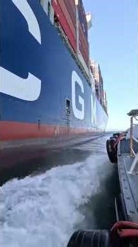 Small boat boarding massive cargo ship