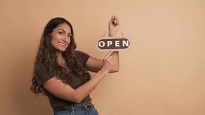 Woman pointing to the open sign of an space