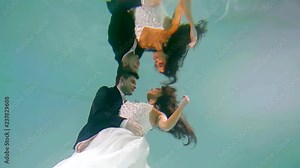 wedding ceremony under water the couple hugging in the pool
