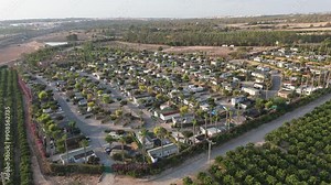 A lateral tracking shot with a drone moves from right to left across a vibrant caravan park near Torrevieja, showcasing the area’s lush layout with a lake visible on the left.