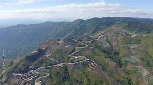 Aerial view of cars driving on curved, zigzag curve road or street on mountain hill with green natural forest trees in rural area of Phu Tub Berk, Phetchabun, Thailand.