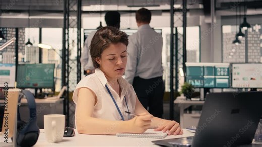 Frustrated businesswoman tearing and crumpling paper after writing mistake at desk. Handwritten notes, ripping pages due to failed attempt and writing error reflect creative block and setback.