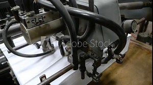 Old vintage printing press is working draws paper in printing factory.