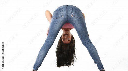 Back view of young woman in tight jeans bending over and smiling