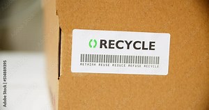 Hands applying RECYCLE Sticker label on a cardboard box with barcode rethink reuse reduce refuse. Stock Video