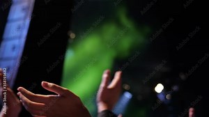 Fan cheering at live outdoor concert , some motion blur at arms.Blurred Music Festival . Laser show on the stage. The crowd of fans.