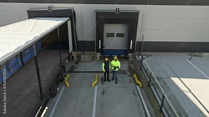 Top view of warehouse receivers unloading of the truck in front of warehouse, checking delivered items.