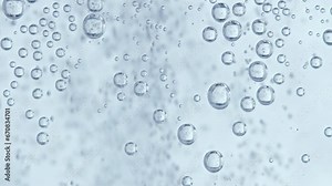 Water bubbles with white background, static bubbles in the foreground and fast moving smaller bubbles in the background.