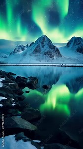 Northern Lights display in the night sky above a mountain range, with dark silhouettes of trees and mountains