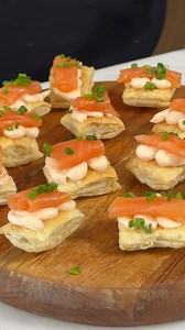 Jour 4/24 des recettes de Noël - Un canapé au saumon léger et frais! Comme on les aime! Ingrédients: - 100g de fromage à la crème - 50g de saumon fumé - Zeste d’un 1/2 citron - 1 feuille de pâte feuilletée - Sel au goût - Morceaux de saumon fumé (pour garnir) - Ciboulette Étapes: 1. Couper la feuille en carrés et les faire cuire sur une plaque au four. 2. Passer le fromage à la crème, le saumon fumé et le jus de citron au mixeur. 3. Déposer le mélange sur les carrés de pâte. 4. Garnir avec les m