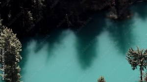 Himalayas. India. The blue lake in a deep gorge (canyon) is silvery with highlights, gentle shadows of trees and the elated mood of the traveler who was lucky to see such