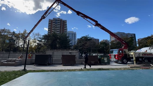 This concrete pump truck is putting in the work — stretching its boom...