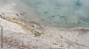 an active geyser spring with an intermittent discharge of water ejected turbulently and accompanied by steam