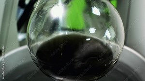 Getting essential oil from herbs in a glass flask, Distillation.slow motion. close up.4K video. Liquid distillation machine. Used in cosmetic factories.