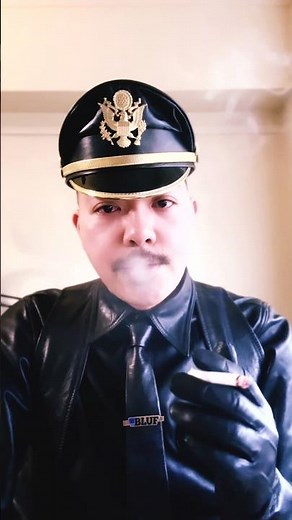 Changing from loungewear to leather cop uniform.⁡And he smokes cigarettes with leather gloves on.