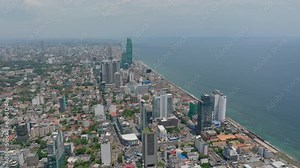 Fly high above city. Tall buildings in coastal urban neighbourhood. High rise hotels or residential towers. Colombo, Sri Lanka