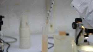 Scientist preparing water sample with pipette. Artemia shrimp water sample analysis