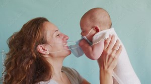 Little child takes off mother's mask. The child does not want to wear a medical mask.