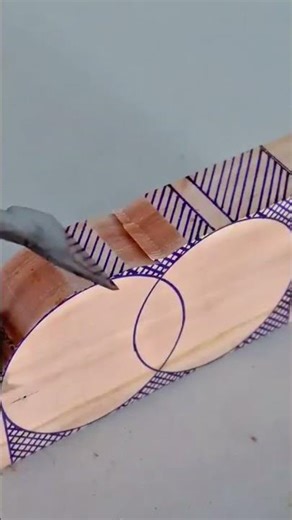 shaping wood blocks using sharp metal chisels to carve out precise oval patterns from light timber