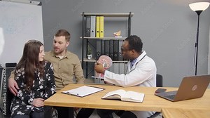 The doctor explains various treatment options while using a model to illustrate the anatomy of the ear