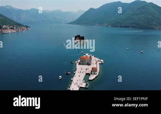 Panoramic pier walkway and islet, couples strolling along sundrenched stone, small boats docking, secluded cypress isle nearby, relaxed Stock Video Footage - Alamy