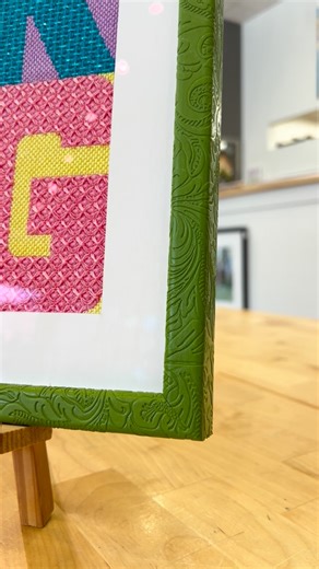 Dreaming of spring with this one🪻🌷☀️ This vibrant spring needlework was the perfect ‘pick me up’ during this chilly weather. We loved getting the chance to use a leather wrapped Bella Moulding frame. The lime green matches the piece perfectly, creating a cohesive statement piece for the season ahead. Schedule your custom framing appointment today! (Link in bio) For more custom framing information check out our website and blog. #mainstreetart #milfordmi #downtownmilfordmi #customframing #milfo