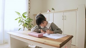 Elementary school girl studying in the living room