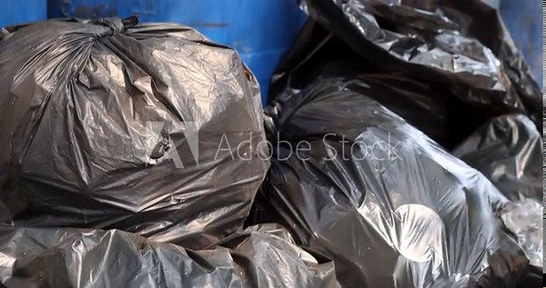Pile of black garbage bags plastic at a bin, Garbage pile, Plastic waste, Pollution, and urban waste management issues