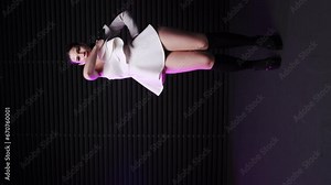 Beautiful go-go dancer in a white mini-dress and black gloves dances