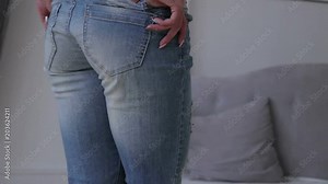 Girl slowly takes off jeans