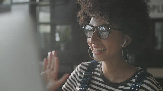 Young office worker greeting colleagues on a video call - Free Stock Video