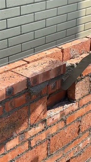 Pour cement from the bucket onto the bricks and install the bricks to form a wall #shortvideo #viral