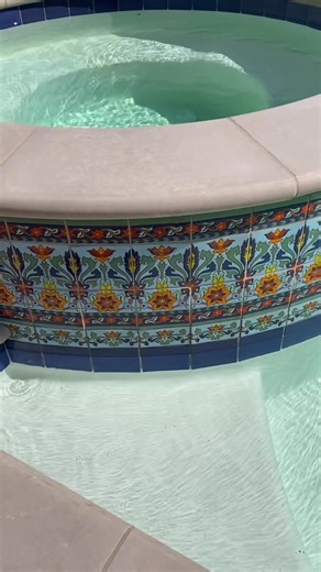 A close up of this stunning custom tile on a swimming pool & spa we designed and built ✨ Located on Xiemeno in Belmont Shore, California. #pooldesign #custom #tile #spanishstyle #poolcontractor