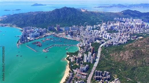 Aerial skyview of Tuen Mun subway extension project in Hong Kong, featuring elevated railway construction along Tuen Mun River and road, new station development and temporary work platforms