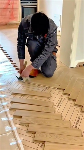 installing wood floor panels in a herringbone pattern with tools and precision