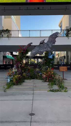 A new Sunrise on the Reaping “Sunrise Gardens” floral installation has appeared at the Hollywood & Highland archway in Los Angeles.The display went live at sunrise on April 8 as part of a nationwide rollout of installations inspired by the film.The quote: “It takes a lot to break these two.” On the back: “You can’t count on things happening tomorrow just because they happened in the past.”See more on my instagram and stay tuned. 🎥: @ tellezcustomprops IG