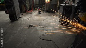 Beautiful sparks are flying from the grinder.Work in production with metal. A disk that rotates and cuts metal close up. Sparks flying from the place of cutting metal. Industrial concept.