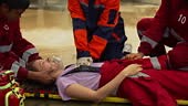First aid crews perform CPR on a female firefighter who was injured...