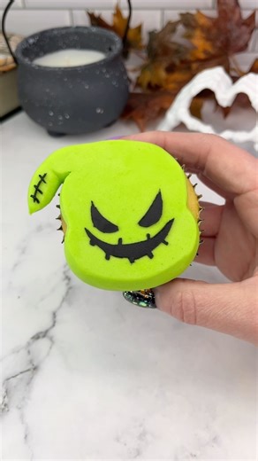 Oogie Boogie cupcakes 💚🖤 The Nightmare before Christmas time is here 💚🖤 Who’s your favourite character? 💚 Use a large round piping tip (ateco 809) to add green buttercream for the face. I added the pointy part of the hood using piping tip 2A. 💚 Press the buttercream down onto parchment paper to achieve a flat surface. I shaped the point with a small metal spatula here to make it look neater. 💚 Freeze the cupcake for 15 minutes. 💚 Remove the parchment paper and attach your stencil to the 