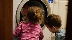 children watching washing machine