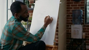 Young man learning drawing technique on canvas at art class lesson, attending workshop with teacher to become artist and draw sketch. Creative student working on personal development.