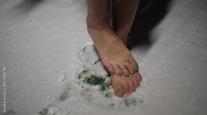 Barefoot woman shivering from the cold while standing in the snow