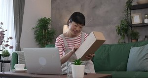 Japanese woman check box of received package or product at home