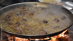 Authentic Valencian paella. Cooking rice with meatloaf. A stew paella, with chickpeas, rice, vegetables and meatloaf. Meat and vegetable paella
