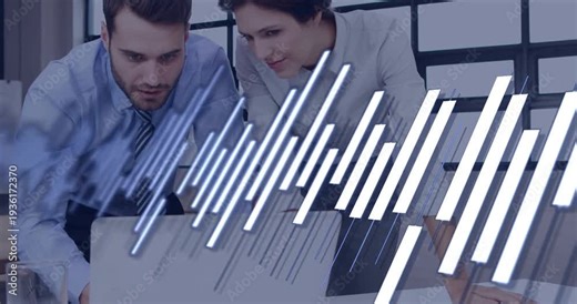 Business duo leaning over laptop and plans while light bars sweeping across shot, revealing data