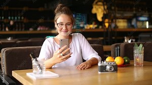 Mixed race woman picks up her smartphone, facial recognition system gets face detection scanning to unlock the device with overlay graphics. Infrared camera scans female face. Biometry.