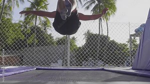 Professional gymnast jumping on the trampoline and doing tricks in slow motion Stock Video